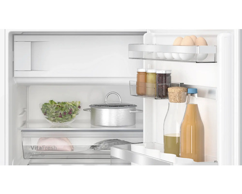 Intérieur d''un réfrigérateur avec des aliments tels que des œufs, de la salade et des boissons