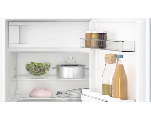 Intérieur d''un réfrigérateur avec des aliments comme de la salade, de la confiture et des boissons