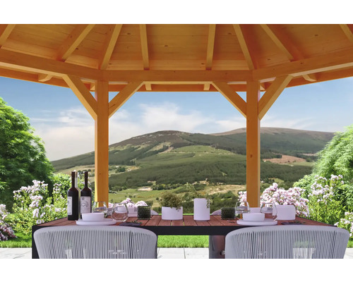 Holzpavillon mit Esstisch und Berglandschaft im Hintergrund