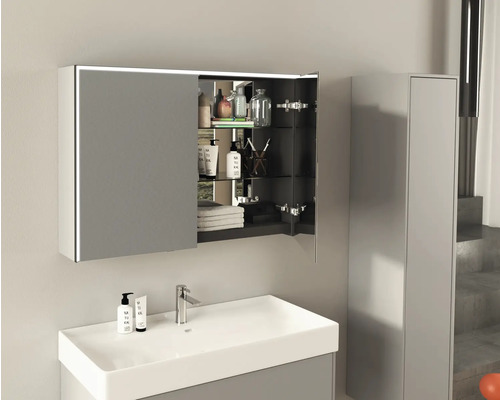 Salle de bains avec lavabo, robinet et armoire de toilette ouverte avec éclairage