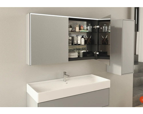 Armoire de toilette ouverte avec éclairage au-dessus d''un lavabo dans une salle de bains
