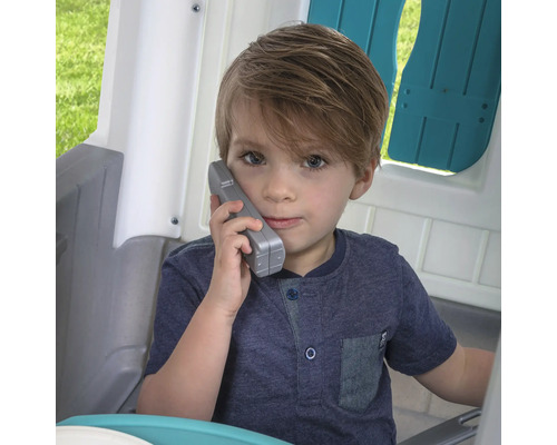 Garçon parlant au téléphone dans une cabane