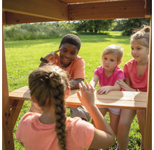 Kinder sitzen an einem Holztisch im Freien und interagieren miteinander.