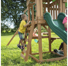 Kind klettert auf ein Spielgerät mit Rutsche im Garten.