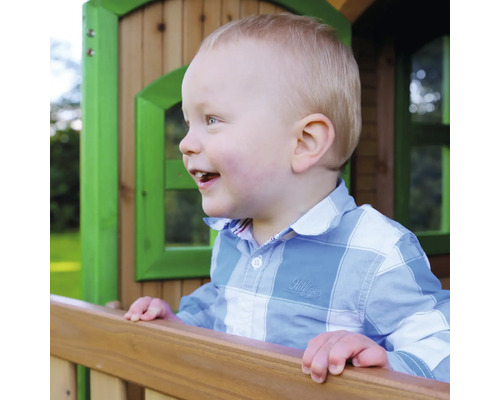 Enfant souriant dans une cabane de jeu