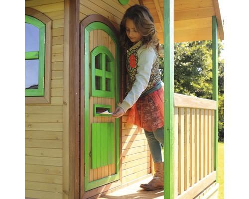 Un enfant glisse une lettre dans la boîte aux lettres d''une cabane en bois