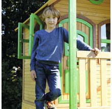 Enfant debout devant une cabane en bois dans le jardin