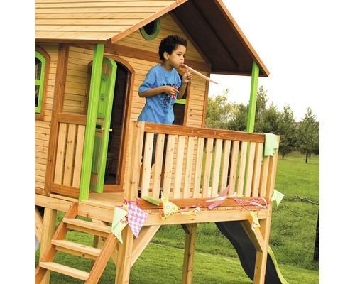 Spielhaus aus Holz mit Rutsche, Leiter und Veranda mit einem spielenden Kind