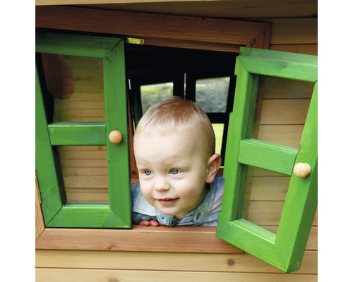 Ein Kind schaut aus dem Fenster eines Spielhauses.