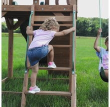 Mädchen klettert auf eine Holzleiter eines Kinderspielhauses im Freien