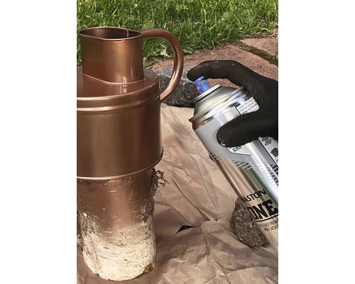 Une personne vaporise un pot avec une bombe aérosol.