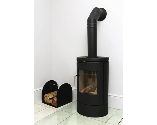 Poêle à bois noir avec bois et panier à bois dans une pièce lumineuse.