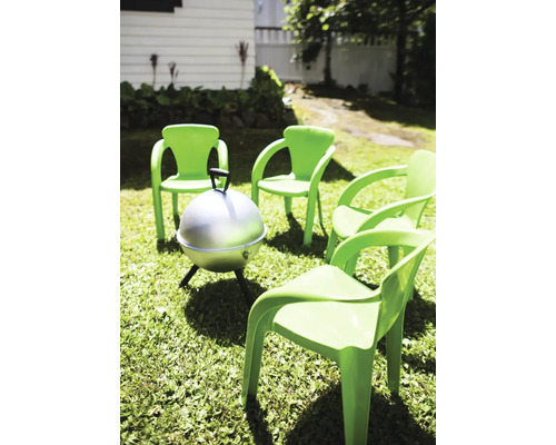 Scène de jardin avec quatre chaises vertes et barbecue sur pelouse