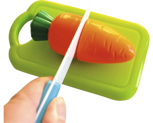 Couteau jouet coupant une carotte jouet sur une planche à découper jouet