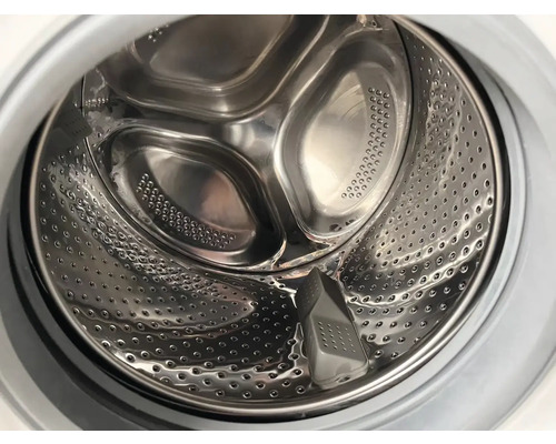 Vue intérieure d''un tambour de machine à laver en acier inoxydable avec des trous