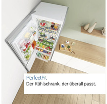 Geöffneter Kühlschrank mit Lebensmitteln auf einem Küchentisch