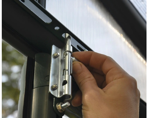 Une main actionne le loquet sur une serre