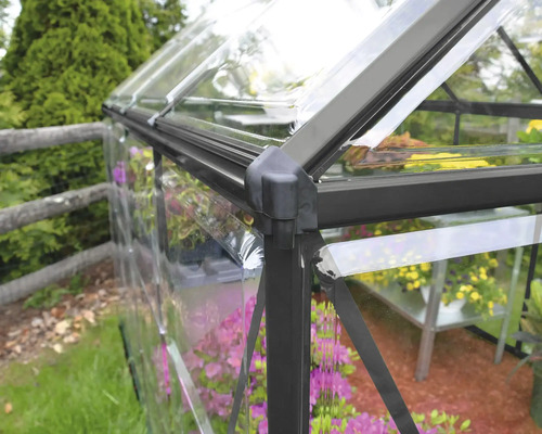 Detailansicht eines Gewächshauses mit transparenten Wänden und einem dunklen Rahmen.