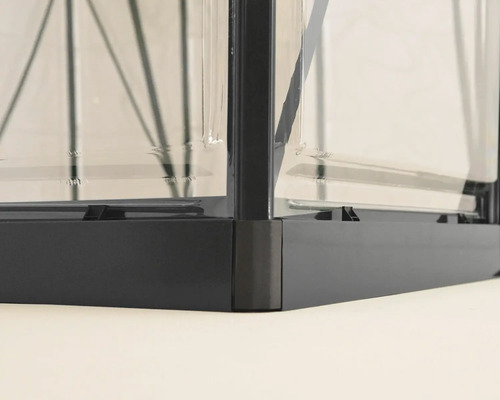 Detailansicht eines Gewächshauses mit Metallrahmen und transparenten Wänden