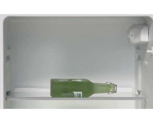Eine Glasflasche mit Apfelsaft liegt im Kühlschrank.