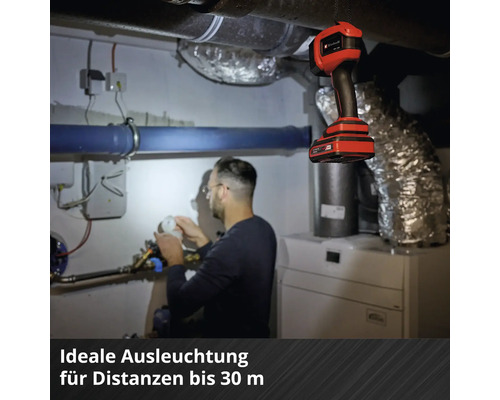 Un homme travaille dans la chaufferie sous la lumière d'une lampe de poche à batterie Einhell.