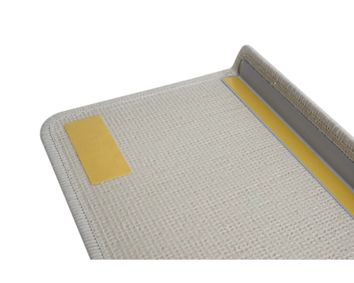 Detailansicht einer hellen Fußmatte mit Klebestreifen zur Befestigung