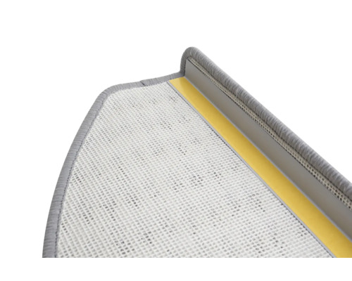 Detailansicht einer grauen Treppenstufe mit Textiloberfläche und Klebestreifen zur Befestigung.