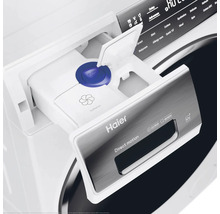 Machine à laver avec bac à lessive ouvert et logo Haier
