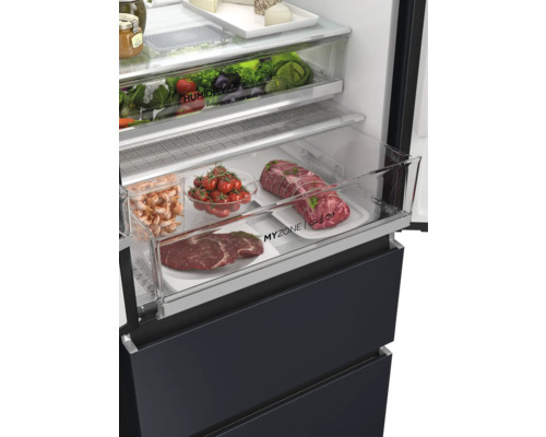 Detailaufnahme eines Kühlschranks mit Gemüse, Fleisch und anderen Lebensmitteln in transparenten Fächern