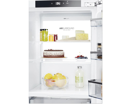 Innenraum eines Kühlschranks mit Lebensmitteln wie Kuchen, Käse und Obst