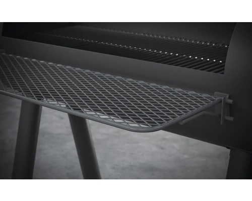 Vue détaillée d''un barbecue au charbon de bois avec grille de rangement.