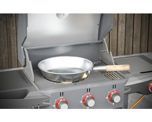 Barbecue avec couvercle ouvert et poêle à frire sur la grille