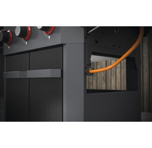 Detailansicht eines Gasgrills mit Schrank und Gasschlauch