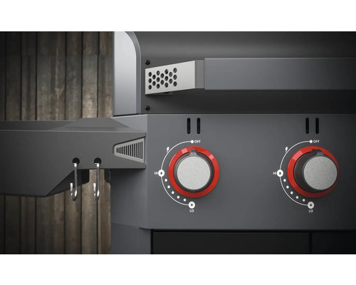 Vue détaillée d''un gril avec des boutons rotatifs pour régler la chaleur