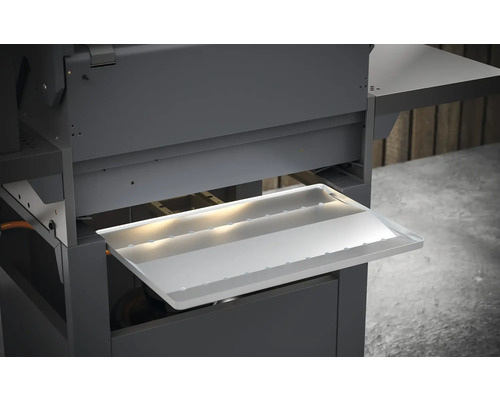 Gros plan d''un barbecue avec bac de récupération des graisses retiré.