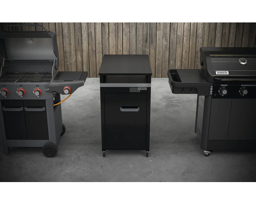 Zwei Gasgrills flankieren einen schwarzen Grillschrank mit Schublade auf Rollen.