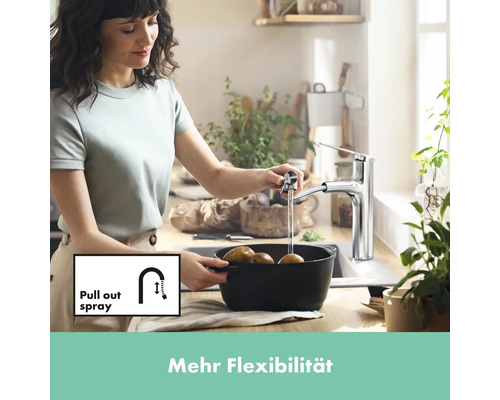 Une femme lave des pommes de terre dans l''évier avec un robinet de cuisine avec douchette extractible.