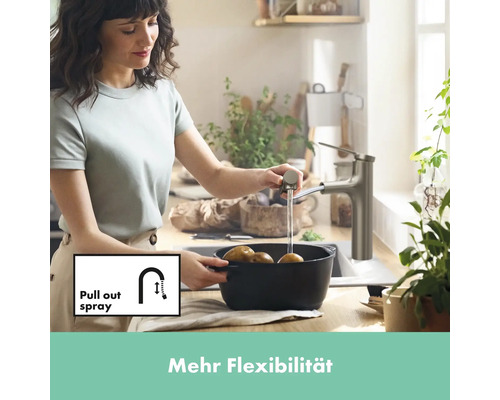 Femme lave des pommes de terre avec un robinet de cuisine avec douchette extractible