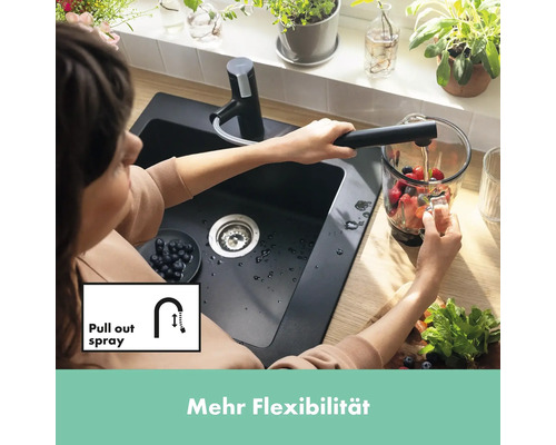 Frau befüllt Krug unter Küchenarmatur mit Ausziehbrause