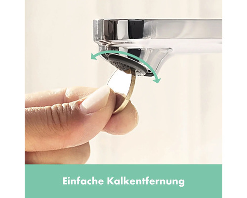 Eine Person entfernt Kalk von einem Wasserhahn mit einer Münze.