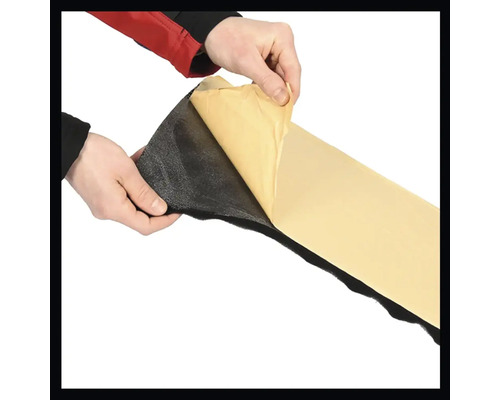 Les mains retirent le film protecteur d''un tapis d''isolation autocollant.