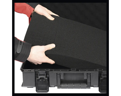 Une personne place un insert en mousse dans une boîte à outils.