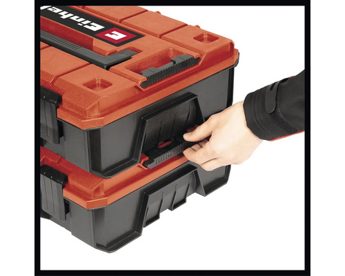 Une personne ouvre une boîte à outils Einhell à une main.