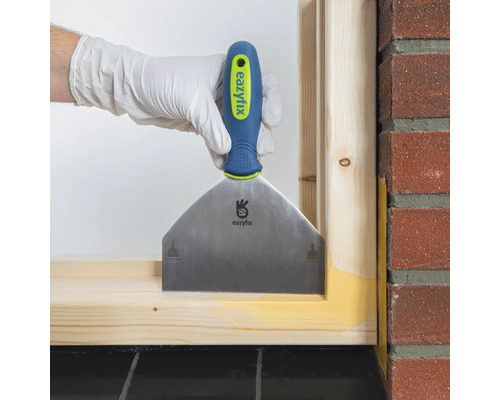 Main avec spatule pour jointoyer un cadre en bois