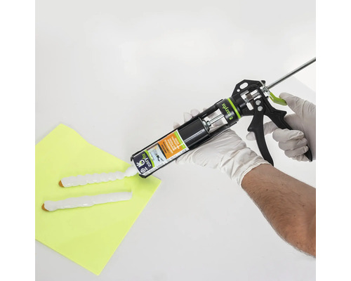 Pistolet à cartouche en cours d''utilisation avec une personne appliquant de la colle