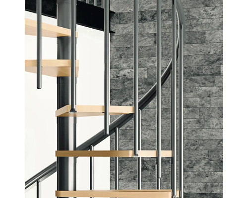 Vue détaillée d''un escalier en colimaçon avec marches en bois et rampes en métal devant un mur de pierre