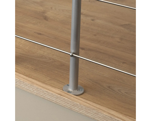 Detailansicht eines Geländerpfostens aus Metall mit horizontalen Edelstahlseilen an einer Treppe