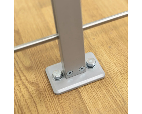 Detailaufnahme eines Geländerpfostens aus Metall mit Schraubbefestigung auf einem Holzboden