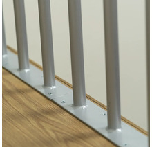 Vue détaillée d''une balustrade d''escalier avec des barreaux métalliques et une fixation au sol.