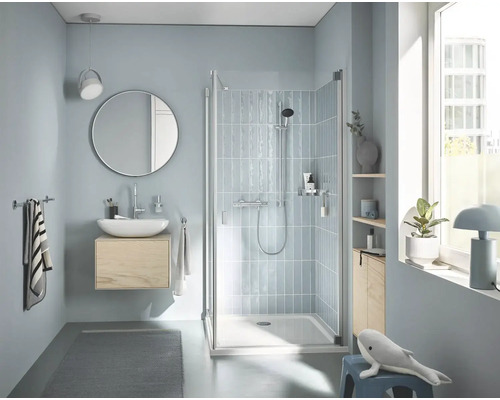 Modernes Badezimmer mit Dusche, Waschtisch, Spiegel und Accessoires.